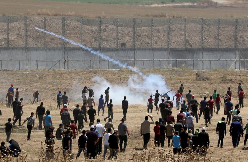 A Palestinian demonstrator hurls back a tear gas canister fired by Israeli forces during a protest marking the 71st anniversary of the 'Nakba', or catastrophe, when hundreds of thousands fled or were forced from their homes in the war surrounding Israel's independence in 1948, near the Israel-Gaza border fence, east of Gaza City.  Reuters