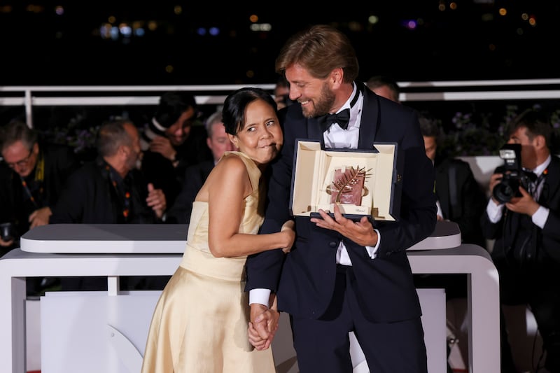 Writer/director Ruben Ostlund, winner of the Palme d'Or for 'Triangle of Sadness,' with actress Dolly De Leon, during the photocall following the awards ceremony at the 75th Cannes Film Festival. AP