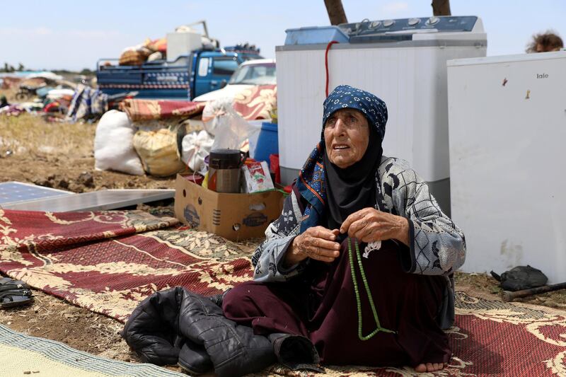 An Internally displaced woman from Deraa province sits near her belongings near the Israeli-occupied Golan Heights in Quneitra, Syria. Alaa Al-Faqir / Reuters