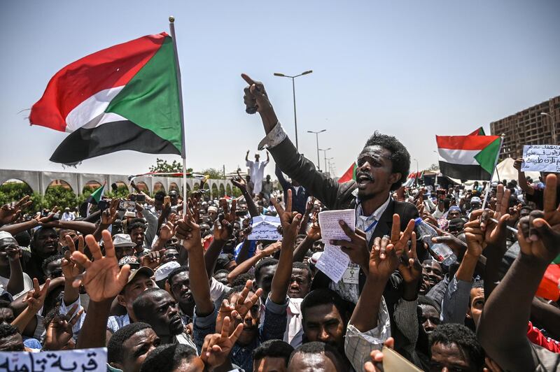 Sudanese protesters wave national flags as they chant slogans during an a sit-in outside the army headquarters in the capital Khartoum on April 26, 2019. - Protesters have massed outside the army complex in central Khartoum since April 6, initially to demand the overthrow of longtime leader Omar al-Bashir.
But since his ouster by the army on April 11, the protesters have kept up their sit-in, demanding that the military council that took over hand power to a civilian administration. (Photo by OZAN KOSE / AFP)