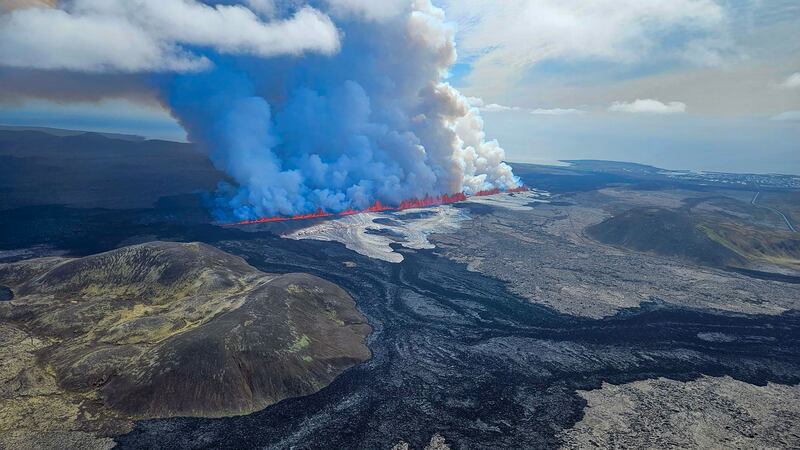 This handout picture released by the Icelandic Coast Guard on May 29, 2024 shows billowing smoke and flowing lava pouring out of a new fissure, during a surveilance flight above a new volcanic eruption on the outskirts of the evacuated town of Grindavik, western Iceland.  A new volcanic eruption has begun on the Reykjanes peninsula in southwestern Iceland, the country's meteorological office said Wednesday, shortly after authorities evacuated the nearby town of Grindavik.  (Photo by HANDOUT  /  Icelandic Coast Guard  /  AFP)  /  RESTRICTED TO EDITORIAL USE - MANDATORY CREDIT "AFP PHOTO  / HANDOUT / ICELANDIC COAST GUARD " - NO MARKETING - NO ADVERTISING CAMPAIGNS - DISTRIBUTED AS A SERVICE TO CLIENTS