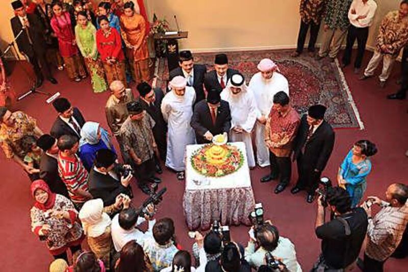 Surrounded by guests, Wahid Supriyadi, centre, the Indonesian ambassador to the UAE, cuts a cake to celebrate the island nation's independence at the embassy in Abu Dhabi.