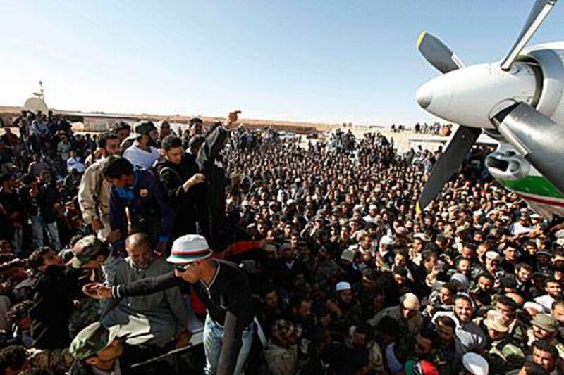 Crowds gather outside of an aeroplane holding Saif Al Islam Qaddafi at Zintan airport, Libya.