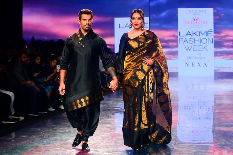Bollywood actors  Karan Singh Grover, left, and Bipasha Basu present creations by Sanjuktta Dutta during Lakme Fashion Week in Mumbai on February 14, 2020.  AFP
