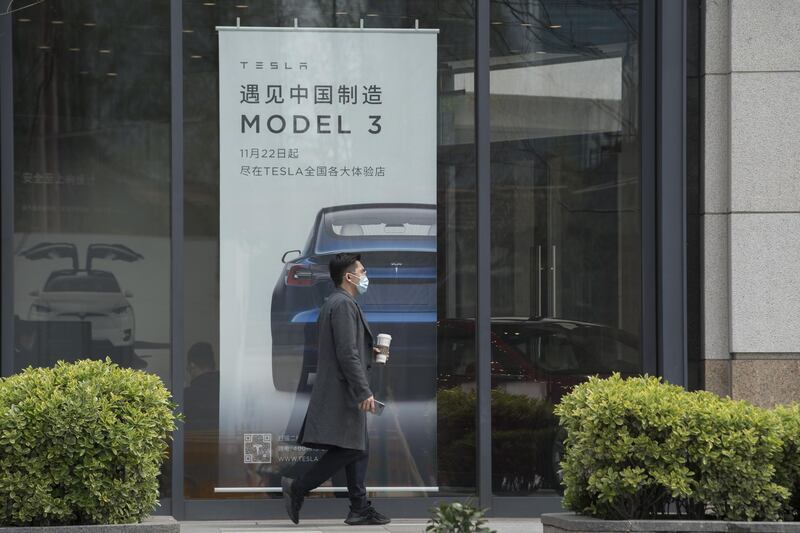 A pedestrian walks past a Tesla Inc. dealership in Shanghai, China on Monday, April 6, 2020. China, the biggest market for electric cars, is considering a reduction in rebates given to buyers and limits on the models that qualify even as it commits to extending the costly subsidy program for another two years. Photographer: Qilai Shen/Bloomberg