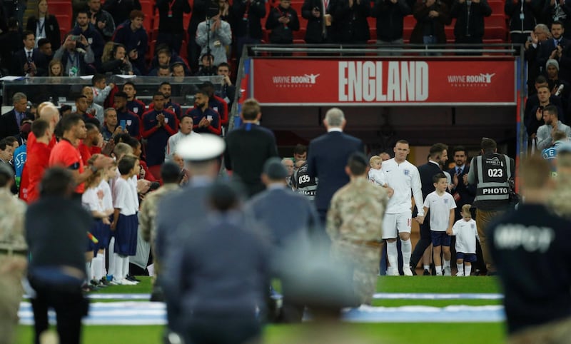England's Wayne Rooney walks out through a guard of honour with his children before the match. Reuters