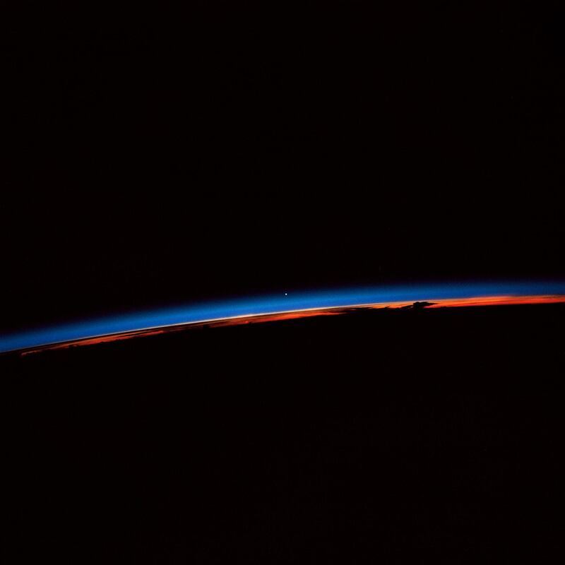 Earth observation captured by crew members onboard Atlantis, Orbiter Vehicle (OV) 104, shows the sunset over the Earth as well as the planet Venus near the center of the frame.