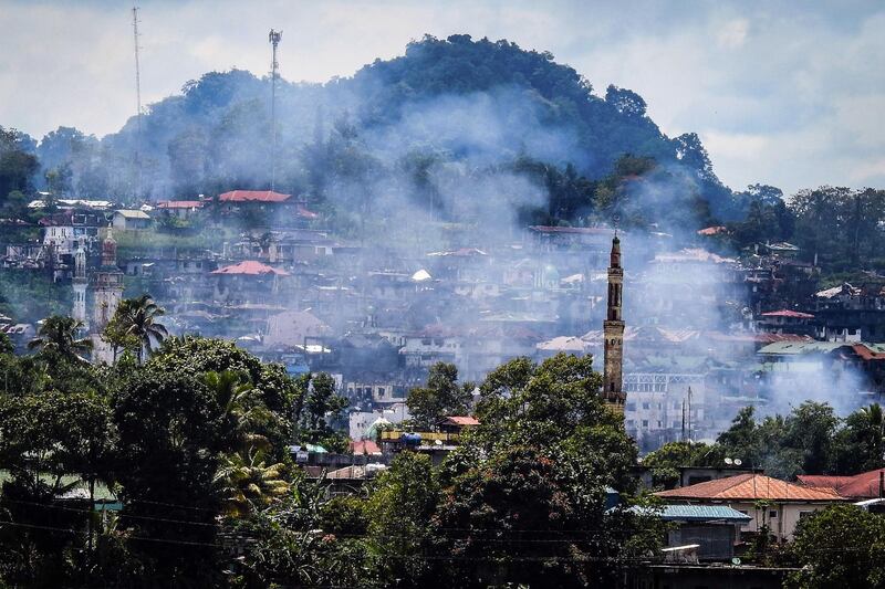 Smoke rises from houses as battles continue in Marawi on the southern island of Mindanao on August 28, 2017.
Soldiers killed 10 suspected militants on August 28 as they attempted to infiltrate by boat, a Philippine city that has been under siege by pro-Islamic State gunmen for over three months, officials said. / AFP PHOTO / Ferdinand CABRERA