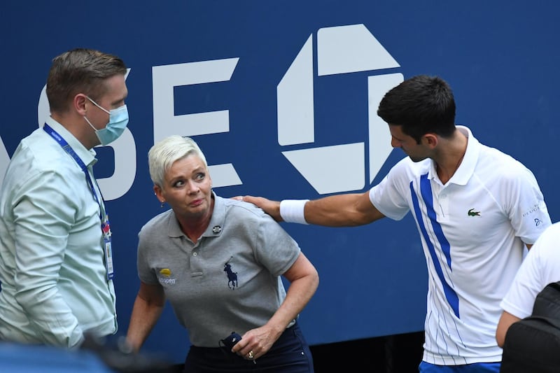 Sep 6, 2020; Flushing Meadows, New York, USA; Novak Djokovic of Serbia and a tournament official tend to a linesperson who was struck with a ball by Djokovic against Pablo Carreno Busta of Spain (not pictured) on day seven of the 2020 U.S. Open tennis tournament at USTA Billie Jean King National Tennis Center. Mandatory Credit: Danielle Parhizkaran-USA TODAY Sports