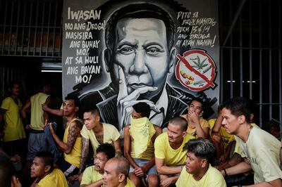 epa06268548 Inmates await clearance next to an image of Philippine President Rodrigo Duterte during a surprise inspection by the Bureau of Jail Management and Penology (BJMP) at the Manila City Jail in Manila, Philippines, 16 October 2017. The BJMP recovered several bladed weapons and illegal contrabands during the operation called 'Oplan Greyhound'.  EPA/MARK R. CRISTINO