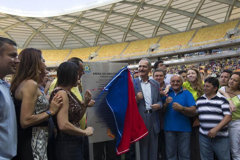 Brazil's Sports Minister Aldo Rebelo (centre, gray suit) uncovers a plaque during the inauguration of the Arena Amazonia Vivaldo Lima on Sunday. Rebelo sounded confident with one of the most problematic stadiums, Curitiba, now more than 97 per cent complete. Bruno Kelly / Reuters / March 9, 2014