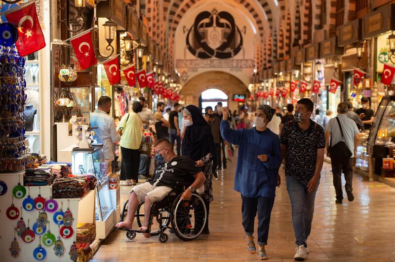People wearing masks for protection against the spread of coronavirus, walk in Spice Market, or the Egyptian Bazaar, in Istanbul, Friday, Sept. 11, 2020. Turkey is getting tough on people who flout self-isolation rules despite testing positive for the coronavirus. An Interior Ministry circular sent to the country's 81 provinces on Friday said people caught leaving their homes despite isolation orders will be quarantined and supervised at state-owned dormitories or hostels.  (AP Photo/Yasin Akgul)