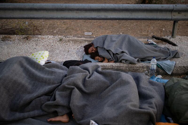 Refugees and migrants sleep on the side of a road following a fire at the Moria camp on the island of Lesbos, Greece. Reuters