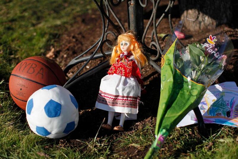 A basketball, soccer ball, doll, flowers and a child's drawing sit at a memorial for shooting victims outside Saint Rose of Lima Roman Catholic Church, Saturday, Dec. 15, 2012 in Newtown, Conn. The massacre of 26 children and adults at Sandy Hook Elementary school elicited horror and soul-searching around the world even as it raised more basic questions about why the gunman, 20-year-old Adam Lanza, would have been driven to such a crime and how he chose his victims.  (AP Photo/Jason DeCrow)
