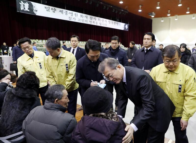 South Korean President Moon Jae-in comforts a relative of a victim of a hospital blaze at a memorial altar for the victims in Miryang, South Korea, January 27, 2018.   Yonhap via REUTERS   ATTENTION EDITORS - THIS IMAGE HAS BEEN SUPPLIED BY A THIRD PARTY. SOUTH KOREA OUT. NO RESALES. NO ARCHIVE.