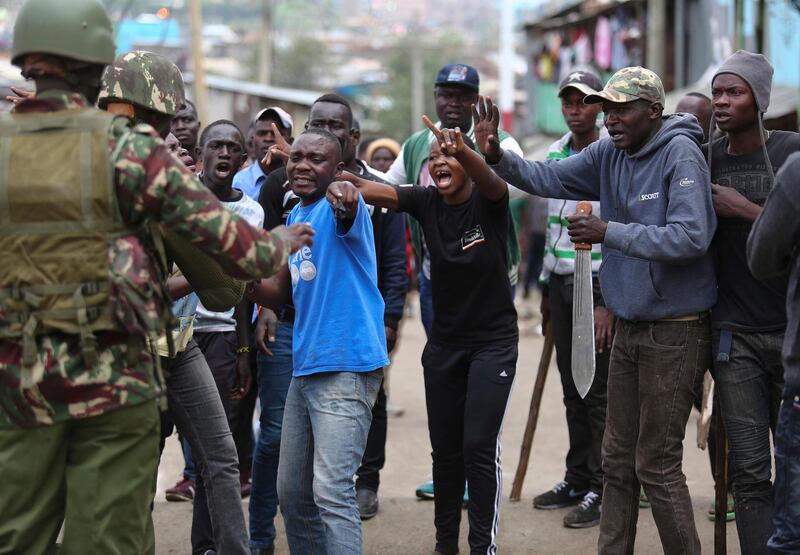 Supporters of the opposition party are stopped by riot police officers in the Mathare slums in Nairobi, Kenya, Monday, Nov. 20, 2017 after Kenya's Supreme Court on Monday upheld President Uhuru Kenyatta's re-election in a repeat vote that the opposition boycotted while saying electoral reforms had not been made. The decision appeared to put an end to a months-long political drama never before seen in Africa that has left dozens dead. (AP Photo/ Brian Inganga)
