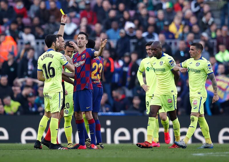 Referee Guillermo Cuadra Fernandez shows Sergio Busquets a yellow card. Getty Images