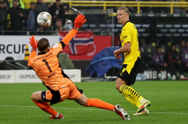 Bayern goalkeeper Manuel Neuer saves from Erling Braut Haaland.