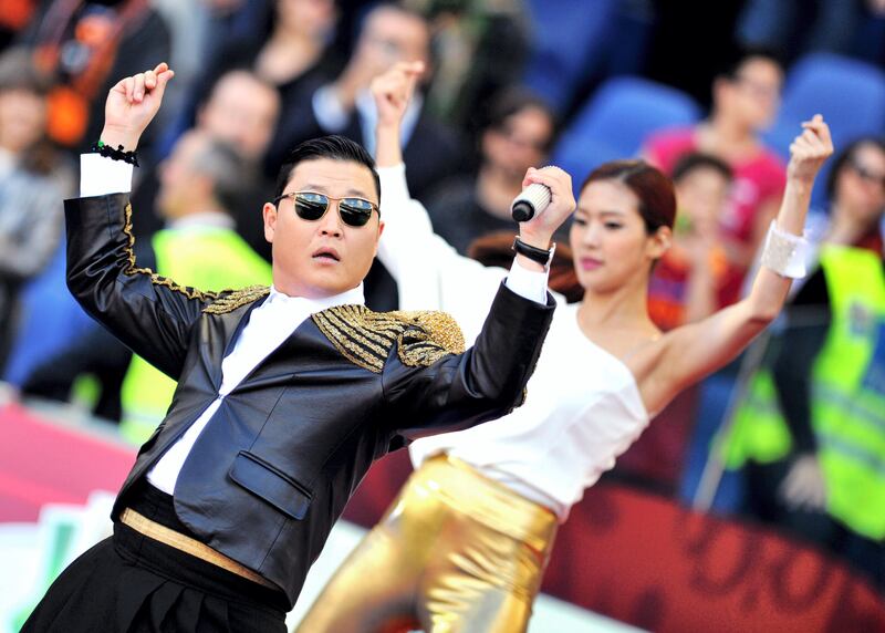 Korean pop artist Park Jae Sang, popularly known as 'Psy', sings as he performs his 'Gangnam Style' song prior to the Italian Cup football final between AS Roma and Lazio at the Rome's Olympic stadium on May 26, 2013. AFP PHOTO / TIZIANA FABI / AFP PHOTO / TIZIANA FABI