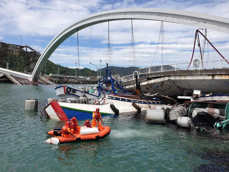 A handout photo made available by Taiwan Coast Guard Administration shows rescuers at the scene of the collapsed Nanfangao Bridge in Nanfangao, Yilan County, northeastern Taiwan. According to media reports, the collapse occured soon after an oil tanker crossed on to the bridge. The structural failure caused the tanker to fall into the waterway and ignite. Civilian and military rescuers have rescued 10 people, including oil the tanker's driver.  EPA