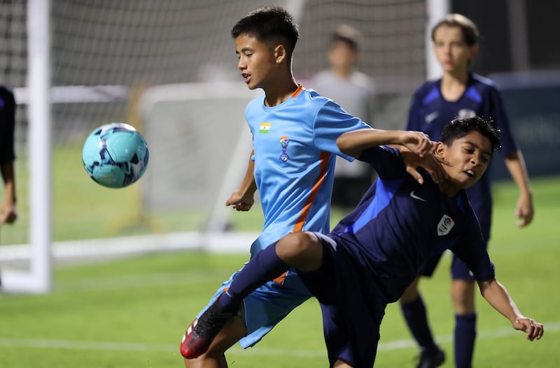 A Minerva Academy player, left, shields the ball from a La Liga HPC player during the U12 Mina Cup final. 