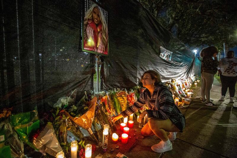 Hannah Longoria leaves flowers as people visit a makeshift memorial on Sunday at the NRG Park grounds, in Houston, Texas, where eight people died in a crowd surge at the Astroworld Festival. AFP