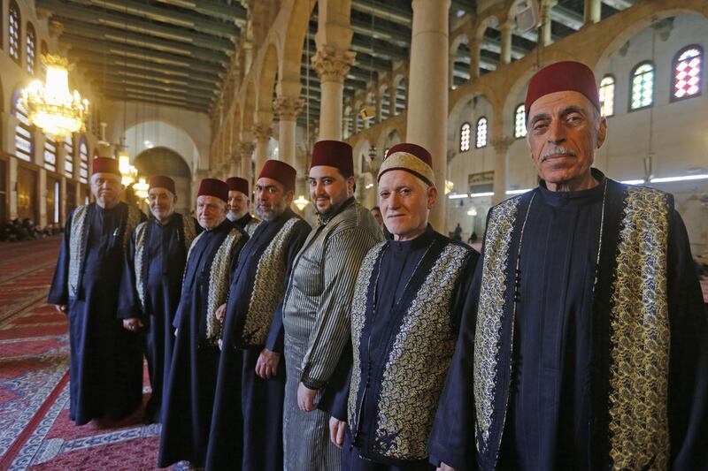 Muezzins, who call Muslims to prayer, pose for a picture at the Umayyad Mosque in the ancient quarters of Damascus. AFP
