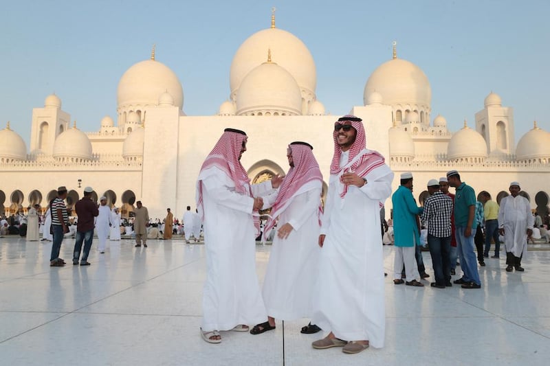 Saudi Arabian men greet each other after Eid Al Fitr prayers at Sheikh Zayed Grand Mosque in Abu Dhabi. Christopher Pike / The National