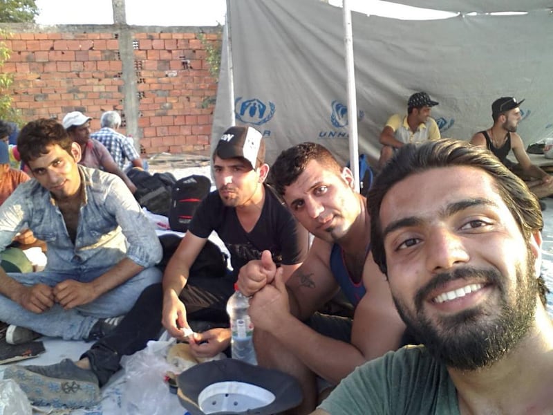 Iraqi Zaid Khalid Mahmood (right) is pictured with other refugees last August on the Macedonia side of the Macedonian-Greek border after having waited for ten hours to cross. The UN's refugee agency (UNHCR) provided them with food and water at this point. Courtesy Zaid Khalid Mahmood 