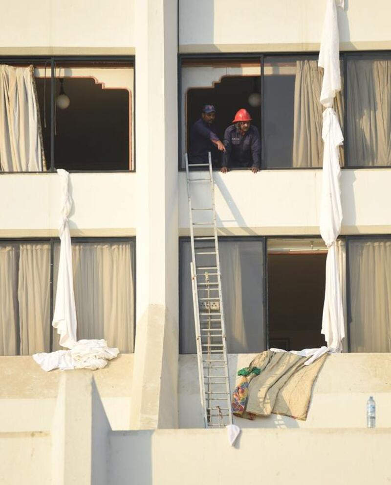 Pakistani fire fighters look from a room of Regent Plaza Hotel. AFP