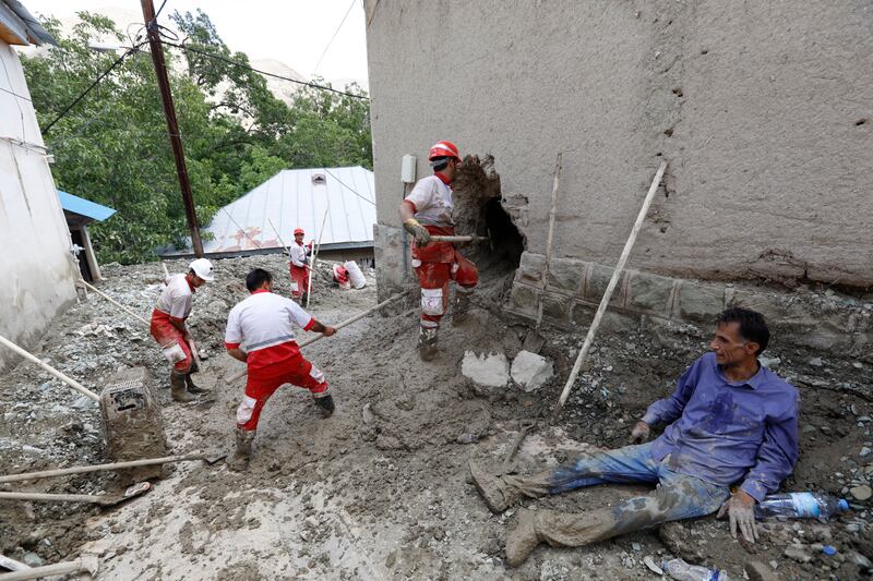 Rescue workers wade through mud during floods in Firuzkuh, Iran. EPA