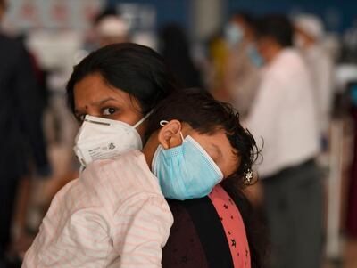 An Indian woman carries a sleeping child as she waits at the Dubai International Airport before leaving the Gulf Emirate on a flight back to her country, on May 7, 2020, amid the novel coronavirus pandemic crisis.  The first wave of a massive exercise to bring home hundreds of thousands of Indians stuck abroad was under way today, with two flights preparing to leave from the United Arab Emirates.
India banned all incoming international flights in late March as it imposed one of the world's strictest virus lockdowns, leaving vast numbers of workers and students stranded.

  


  
 / AFP / Karim SAHIB
