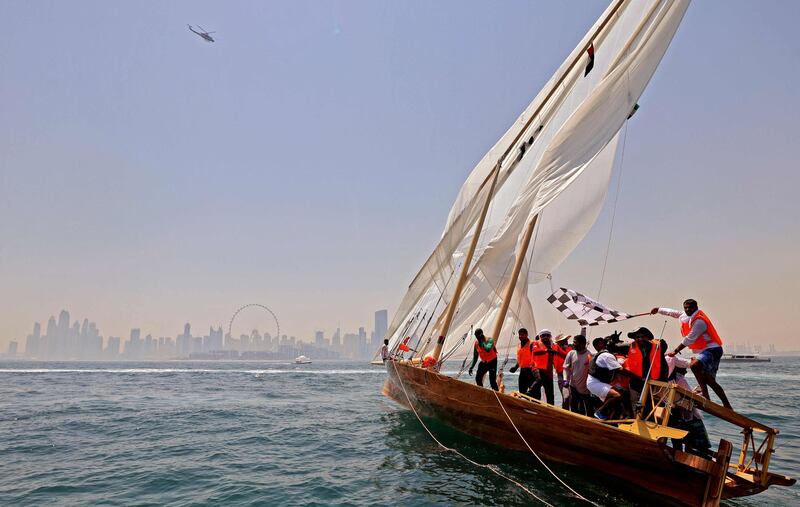 The crew of the 'Namran', owned by Sheikh Zayed bin Hamdan bin Zayed, celebrate after crossing the finish line near Dubai, in the Al Gaffal long-distance dhow sailing race, on Friday. AFP