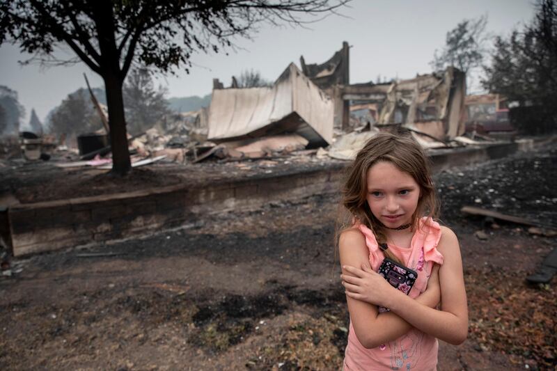 Ellie Owens, 8, looks at destruction caused by wildfires in Talent, Oregon. AP Photo