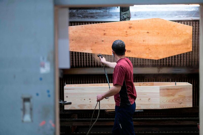An employee of France's biggest coffin-maker, OGF group varnishes a coffin in Jussey, eastern France, amid the spread of the COVID-19, the disease caused by the novel coronavirus.   AFP