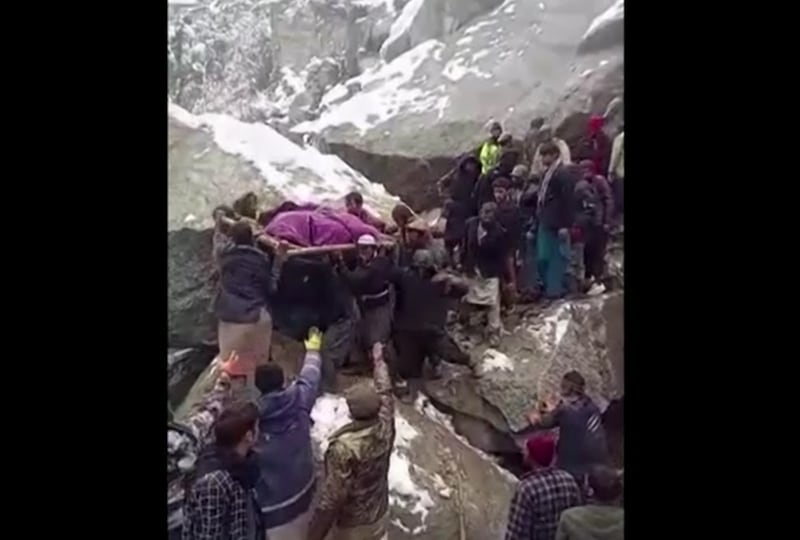 Villagers carrying a body on their shoulders and snow-covered houses buried under the landslide. Reuters