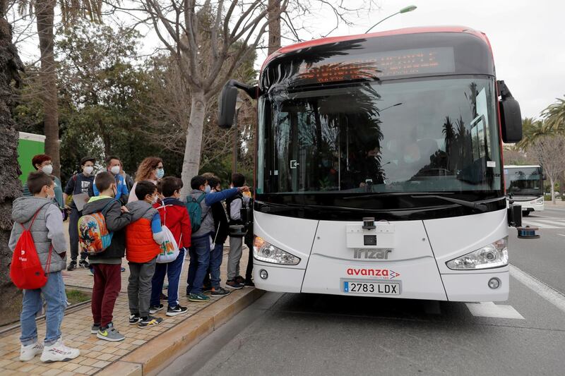 Children wait to take an electric autonomous bus which is driven in autopilot mode during a month test phase with passengers in Malaga, Spain February 24, 2021. REUTERS/Jon Nazca