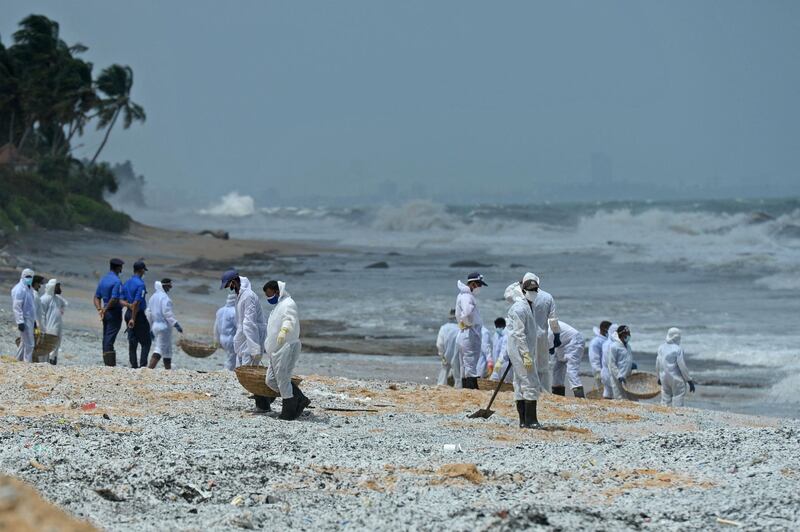 Members of Sri Lankan Navy remove debris washed ashore. AFP