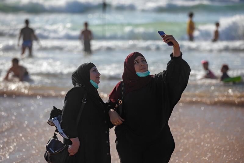 Palestinian women take a selfie as they wear protective face masks during the Eid al-Fitr holiday, at the Mediterranean sea beachfront in Tel Aviv, Israel. AP Photo