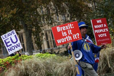 An anti-Brexit campaigner carries placards near a pro-Brexit campaigner in the Westminster district of London, U.K., on Friday, Nov. 16, 2018. U.K. Prime Minister Theresa May is defying demands to quit as she battles to keep control of her fractious government long enough to deliver a Brexit deal that’s drawn ire from across the political spectrum. Photographer: Simon Dawson/Bloomberg