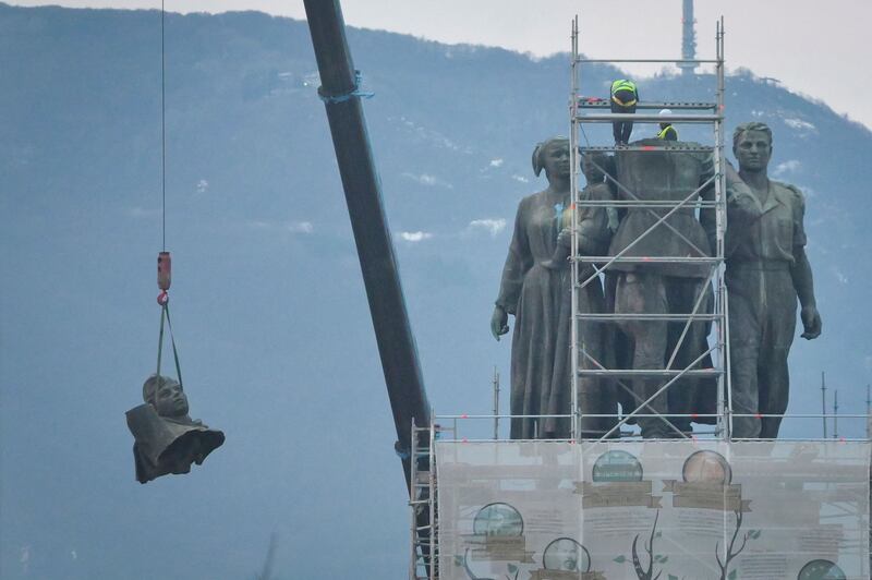 Workers remove a head from the Soviet Army monument depicting a Soviet soldier, a worker and a mother and her child, in Sofia, Bulgaria. Work to dismantle the monument began this week after years of controversy between Russophiles and pro-Europeans in the former Communist country. AFP