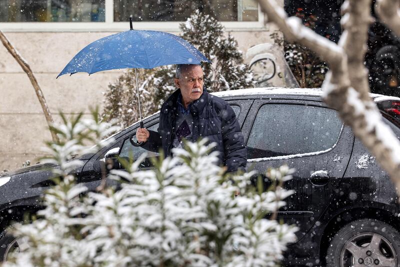 A pedestrian in Tehran prepares for snowfall. AFP