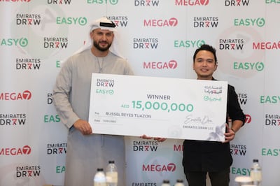 Mohammad Behroozian Al Awadhi, managing partner at Emirates Draw, presents a cheque for Dh15 million to Russell Reyes Tuazon, from the Philippines. Photo: Emirates Draw