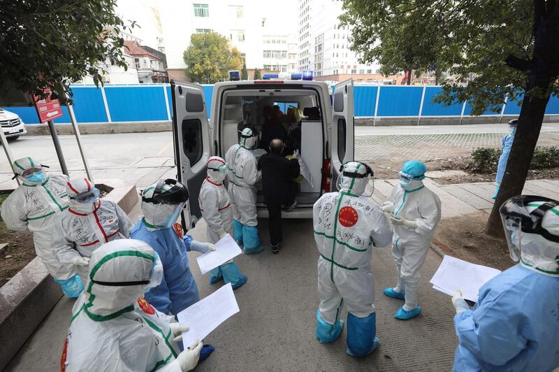 Medical staff assist a patient infected by the coronavirus leaving from Wuhan No 3 Hospital to travel to Huoshenshan Hospital in Wuhan.  AFP