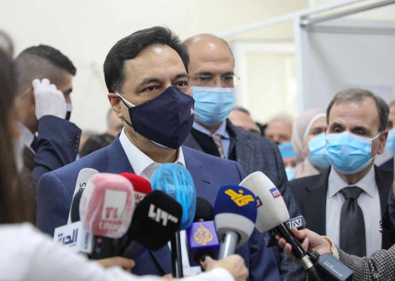 Lebanon's caretaker Prime Minister Hassan Diab talks to reporters at the Rafik Hariri Hospital in the capital Beirut after the country started its Covid-19  inoculation campaign with the Pfizer-BioNTech vaccine on Sunday. AFP