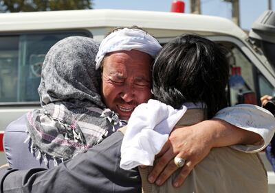 Afghan men hug each other as they mourn during the funeral of their relatives after a wedding suicide bomb blast in Kabul, Afghanistan August 18, 2019. REUTERS/Omar Sobhani