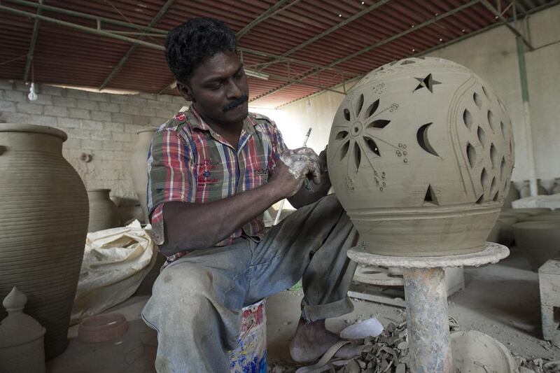 It can take as little as 10 minutes for craftsmen like Rajesh Rajal (shown here) to slice and etch elaborate designs with flower petals, moons and stars into one small pot.Mona Al-Marzooqi/ The National 