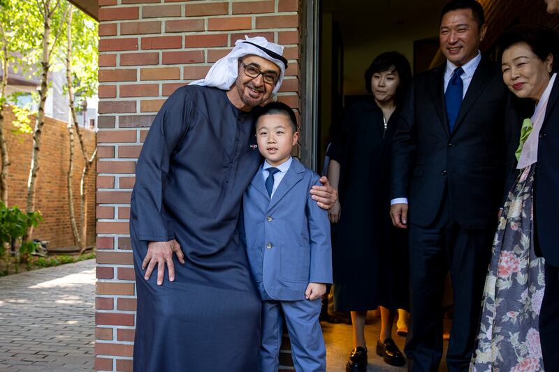 Sheikh Mohamed poses for a photograph with a relative of former South Korean president Lee Myung-bak during a visit to his home.  Ryan Carter / UAE Presidential Court