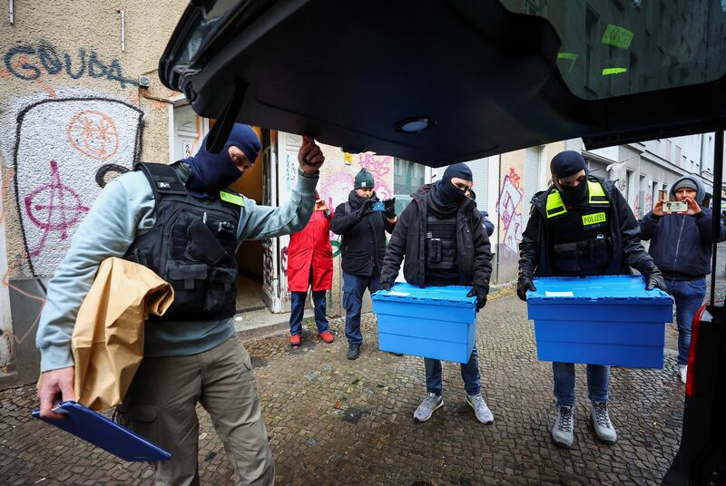 German police officers carry evidence collected during raids. Reuters