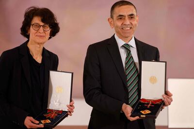 Ozlem Tureci (L) and her husband Ugur Sahin, both scientists and founders of BioNTech, pose with their orders after they were awarded the Federal Cross of Merit (Bundesverdienstkreuz) by the German President on March 19, 2021 at the presidential Bellevue Palace in Berlin. / AFP / POOL / Odd ANDERSEN
